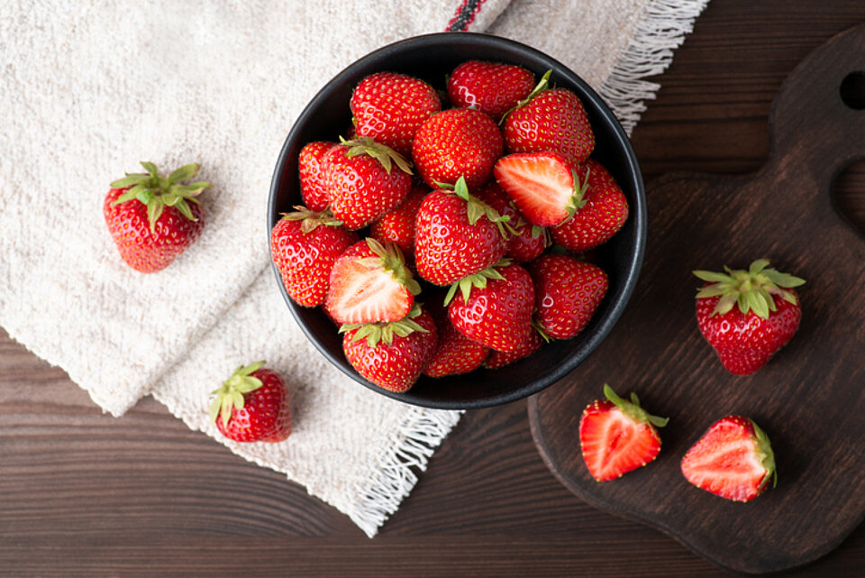7 weetjes over aardbeien Aardbeien in een schaaltje op wit tafelkleed
