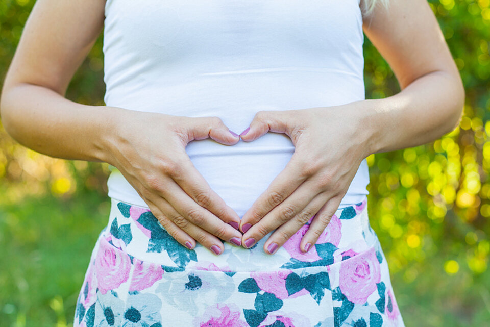 10 x een boost voor gezonde darmen vrouw maakt hartje van haar handen voor haar buik