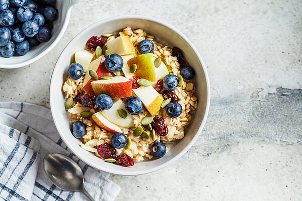 kom met Bircher-muesli, blauwe bessen, appel en cranberries