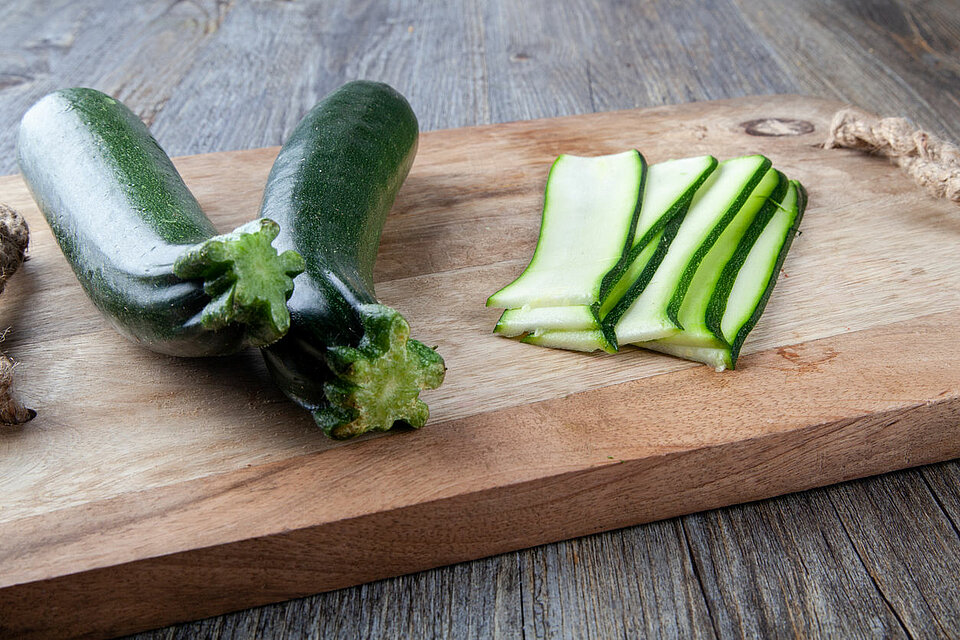 Waarom courgette eten een goed idee is courgettes op een plank deels in plakken gesneden