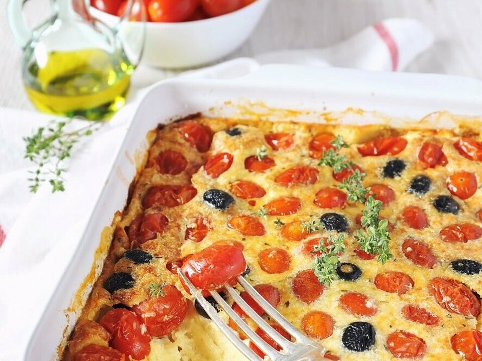 Clafoutis met geroosterde kerstomaatjes Ovenschaal met ei-gerecht en kerstomaatjes
